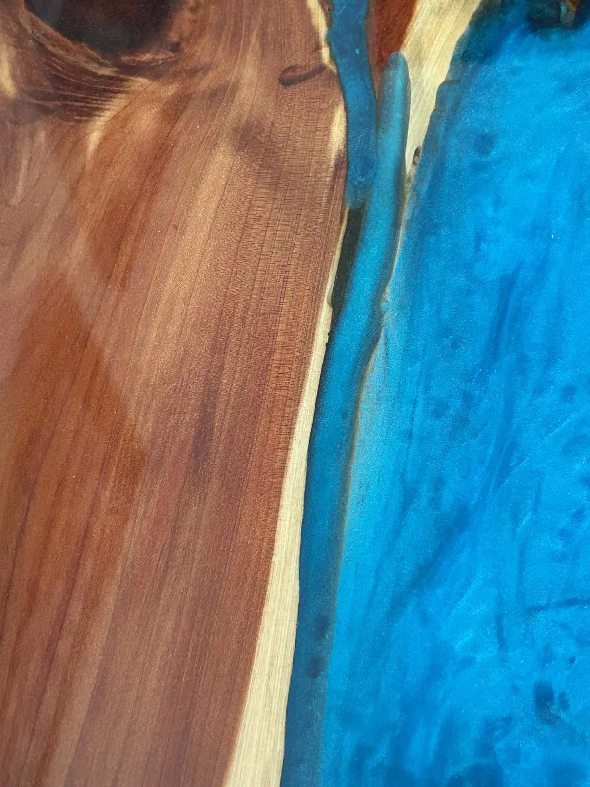 Close-up of a wooden surface next to a blue textured area.