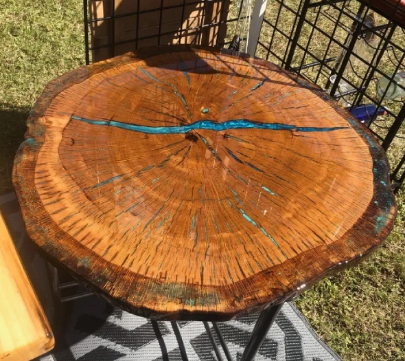 A polished wooden slab with a blue resin-filled crack, used as a table.