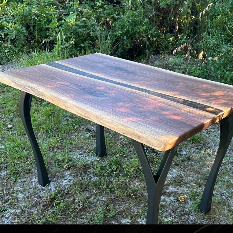 Rustic wooden table with metal legs outdoors.